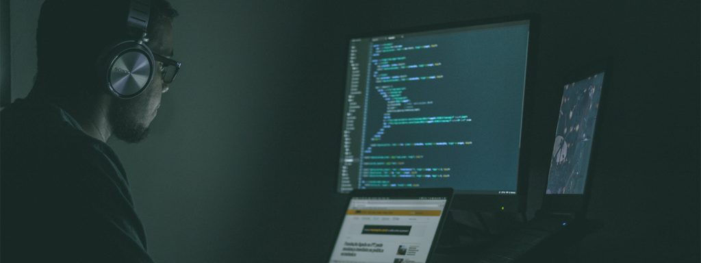 Programmer coding on two desktops