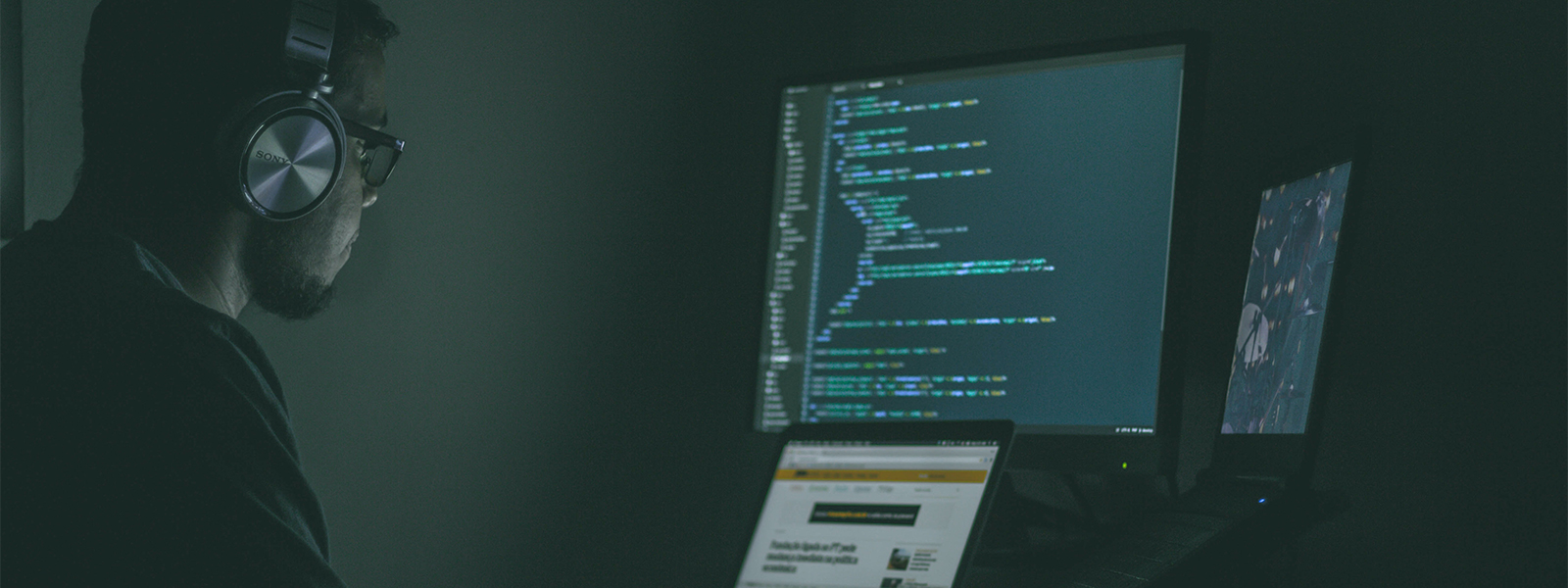 Programmer coding on two desktops
